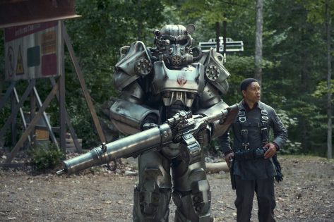 A scene from Fallout, a Brotherhood of Steel Power Suit and Maximus standing in a forest